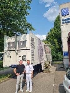 Dr. med. Winfried Haerer, Kardiologe und Internest der Herzklinik Ulm vor dem Medneo Trailor, wo er in der Zusammenarbeit mit medneo Kardio-MRTs durchführte. 